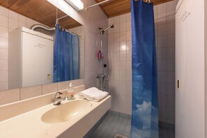Een badkamer met een bad, een wastafel en een douche.