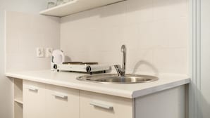 A modern kitchen with white cabinetry, a stainless steel sink, and a built-in electric kettle. - Boutique Apartments - Main Market Square (Kraków)