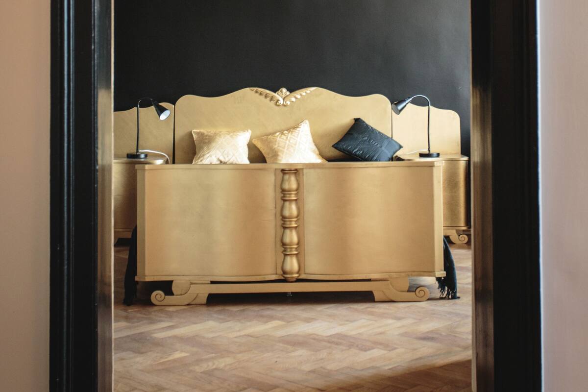 A room with a bed, a lamp, and a hanging light fixture.