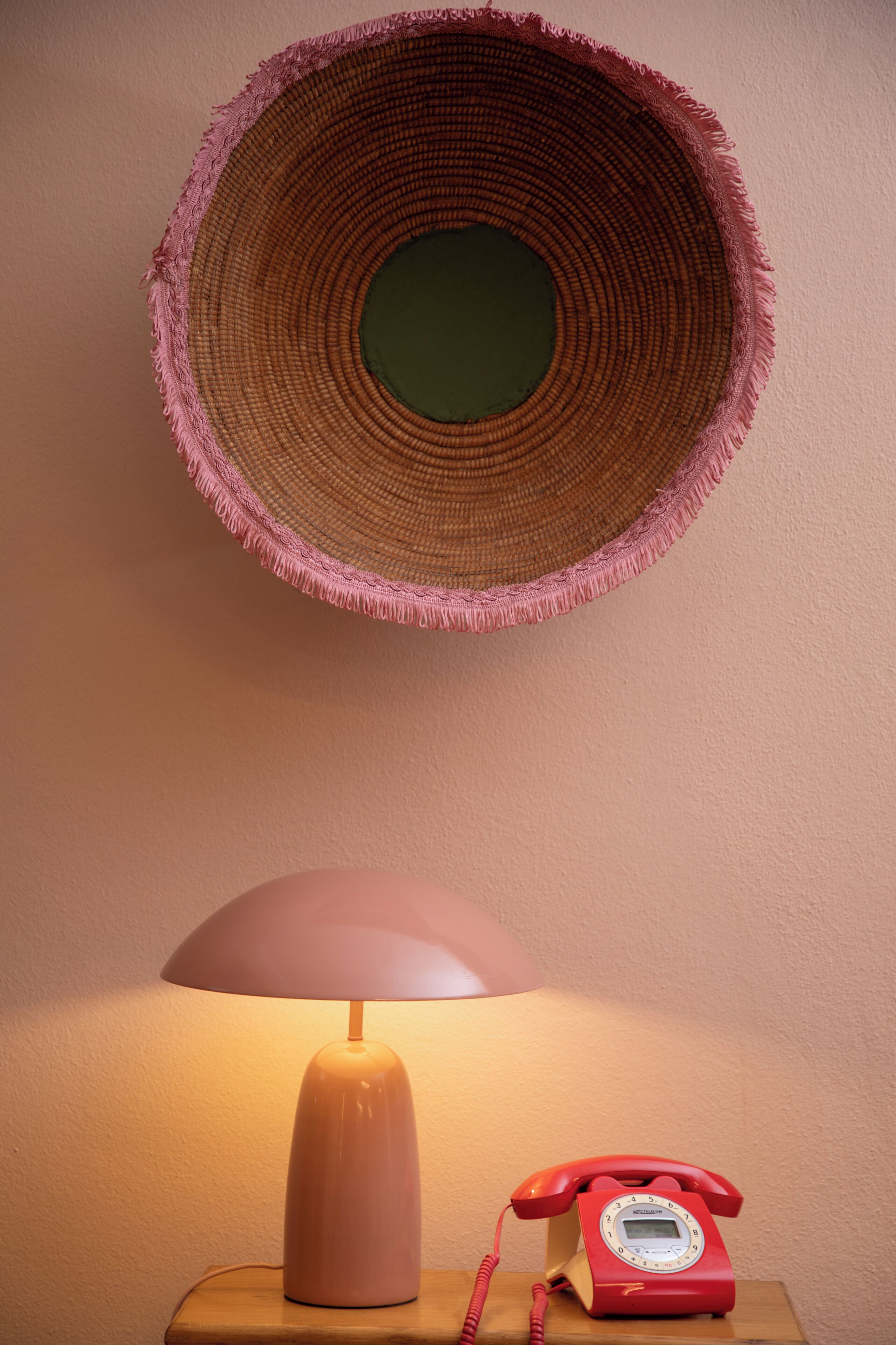 Een lamp, een telefoon en een wandtapijt.