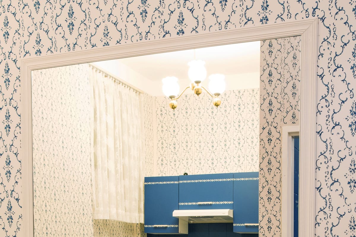 A dining area with a table set for four, chairs, a coffee machine, and a kettle.