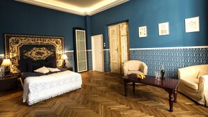 A room with a large bed, a sofa, a wooden coffee table, and a chandelier. - Boutique Apartments - Kazimierz (Kraków)