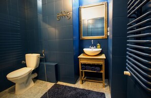 Une salle de bain avec des toilettes, un lavabo et un miroir.