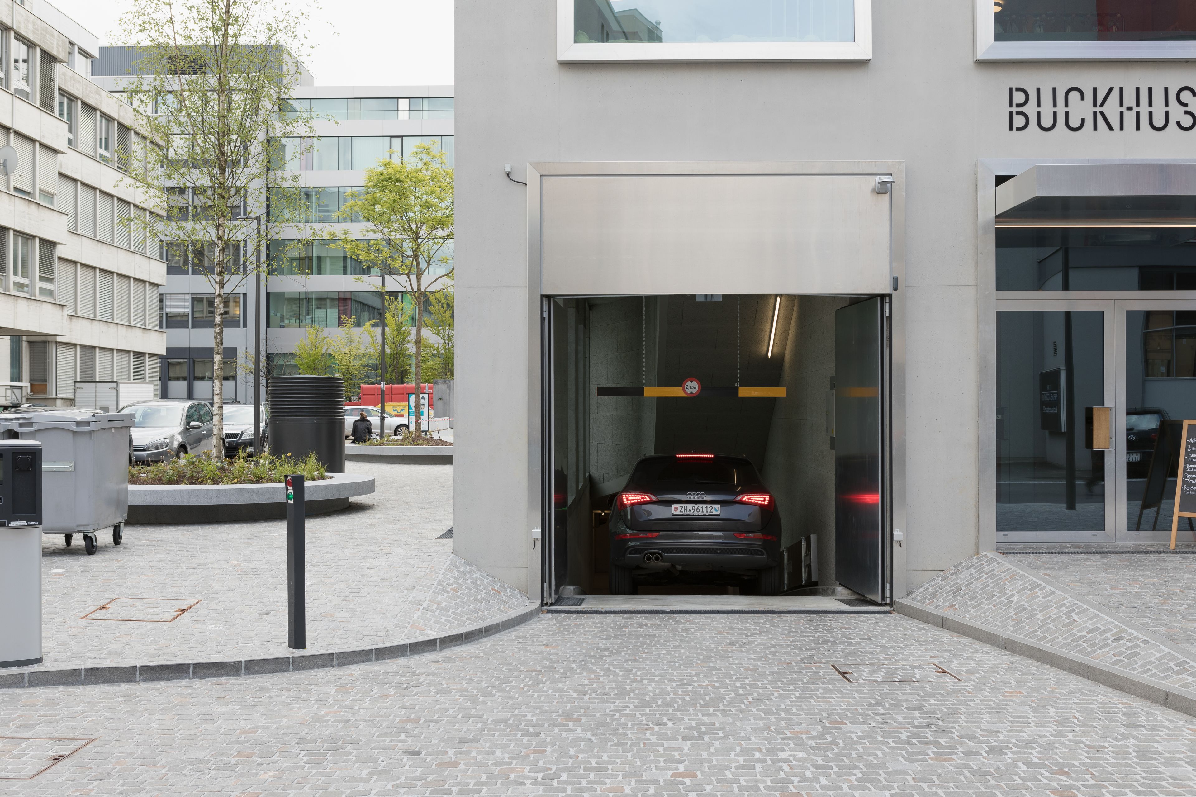 A car entering a building through a glass door.