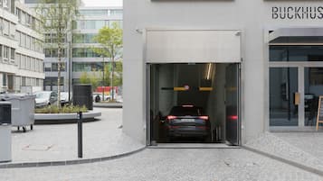 A car entering a building through a glass door.