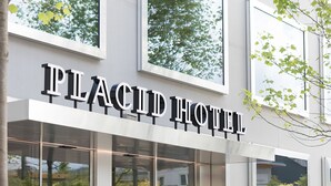Un bâtiment moderne sur lequel on peut voir en évidence l’enseigne « PLACID HOTEL ».