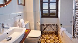 A compact bathroom with a sink, toilet, and shower area.