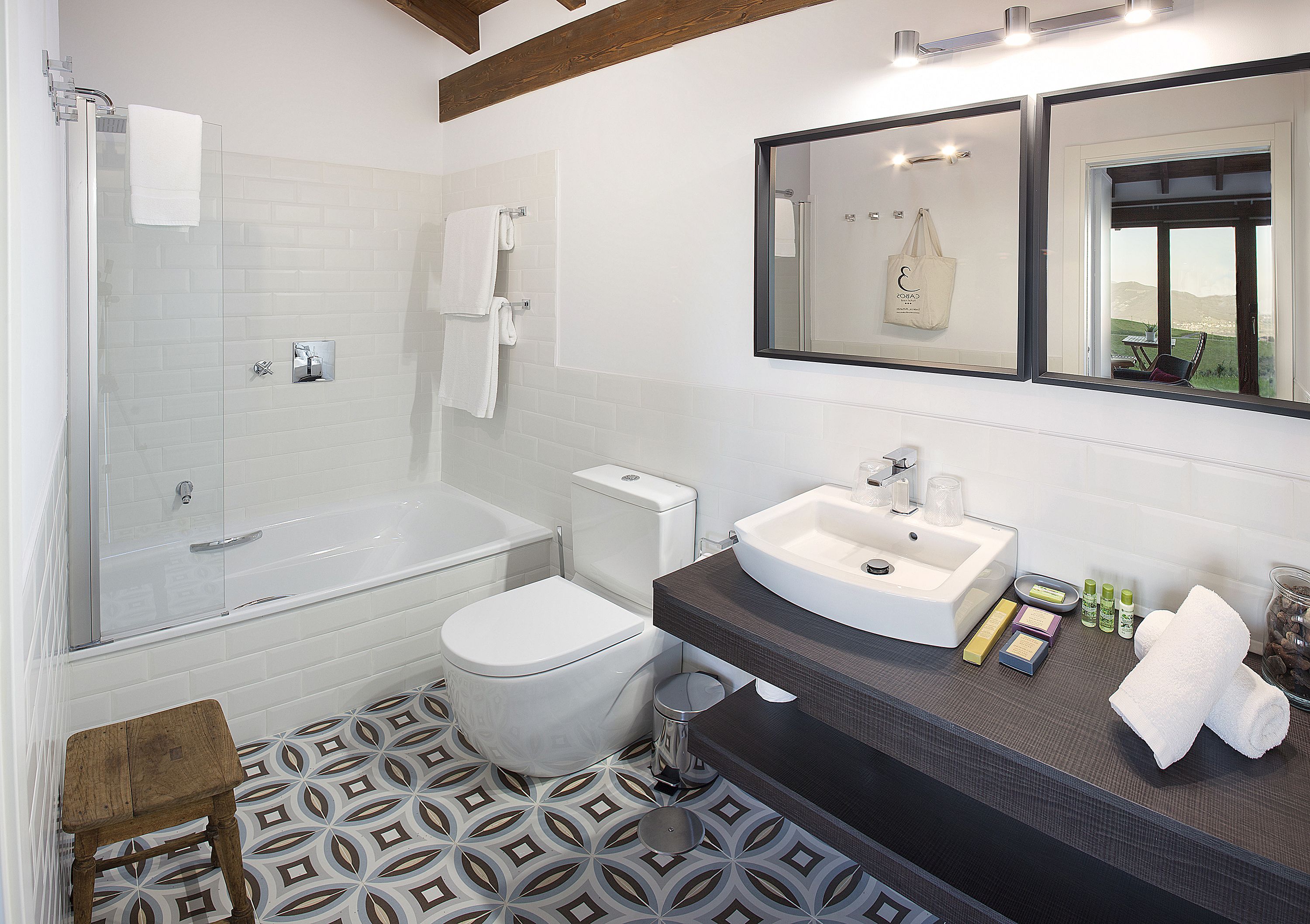 A modern bathroom with a glass-enclosed shower, a white toilet, and a vanity with a sink and mirror.