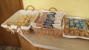 A buffet table with various food items in baskets and trays. - Hotel Ronconi (Rimini)