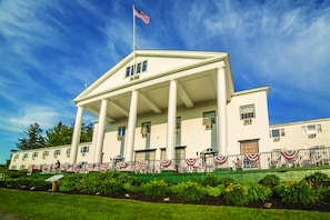 Stately building with a prominent entrance and well-manicured lawn.