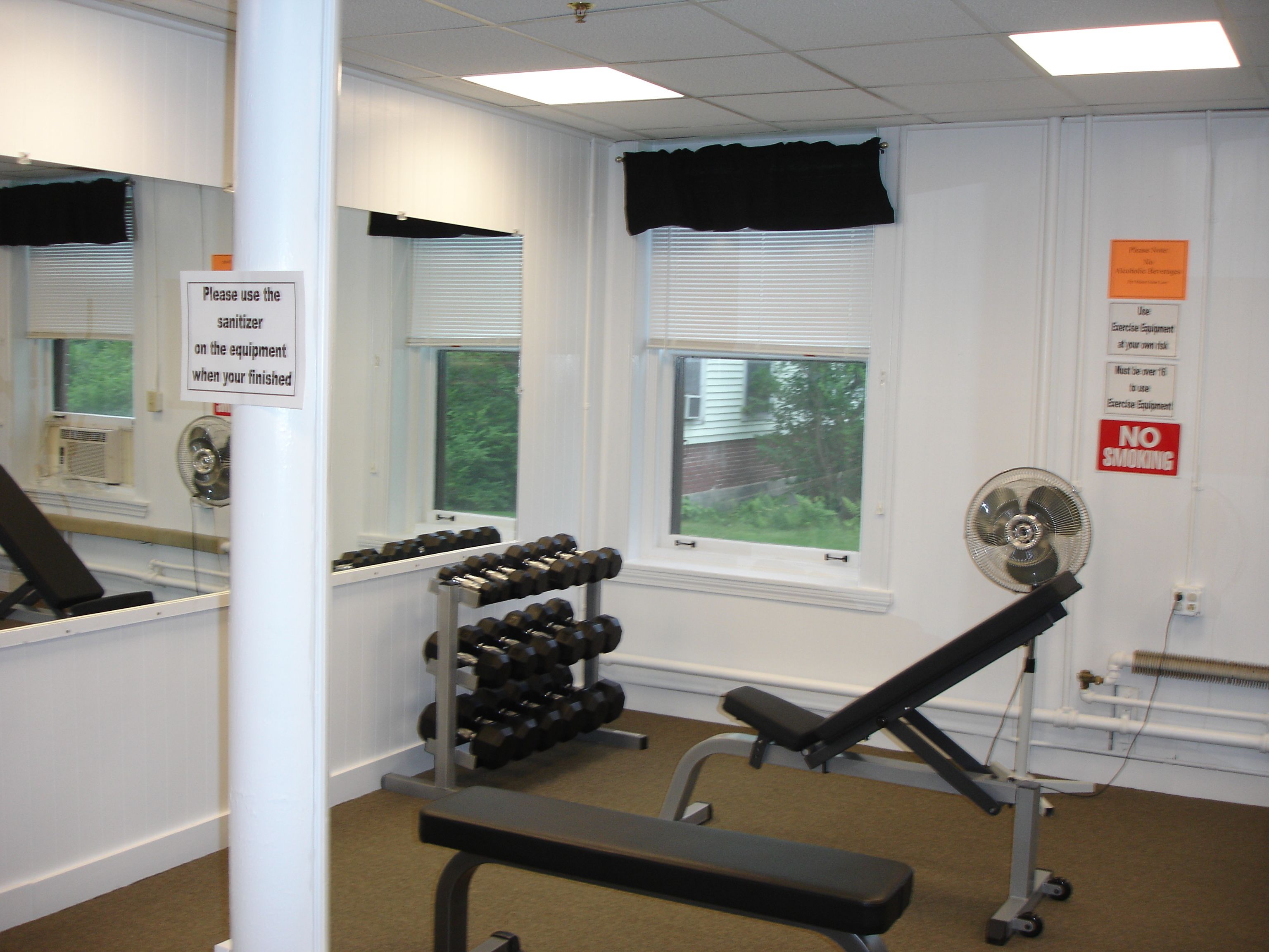 Une salle de sport équipée de matériel d’exercice, d’un banc et d’un porte-haltères.