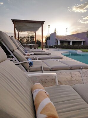 A poolside area with lounge chairs and a covered seating area. - Alesia Hotel Boutique & Spa (Aguascalientes)