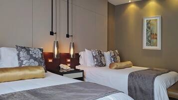 Une chambre d’hôtel avec deux lits, une table de chevet, une lampe et un tableau au mur.