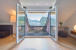 An open balcony with a table and chairs, a sofa, and a lamp.