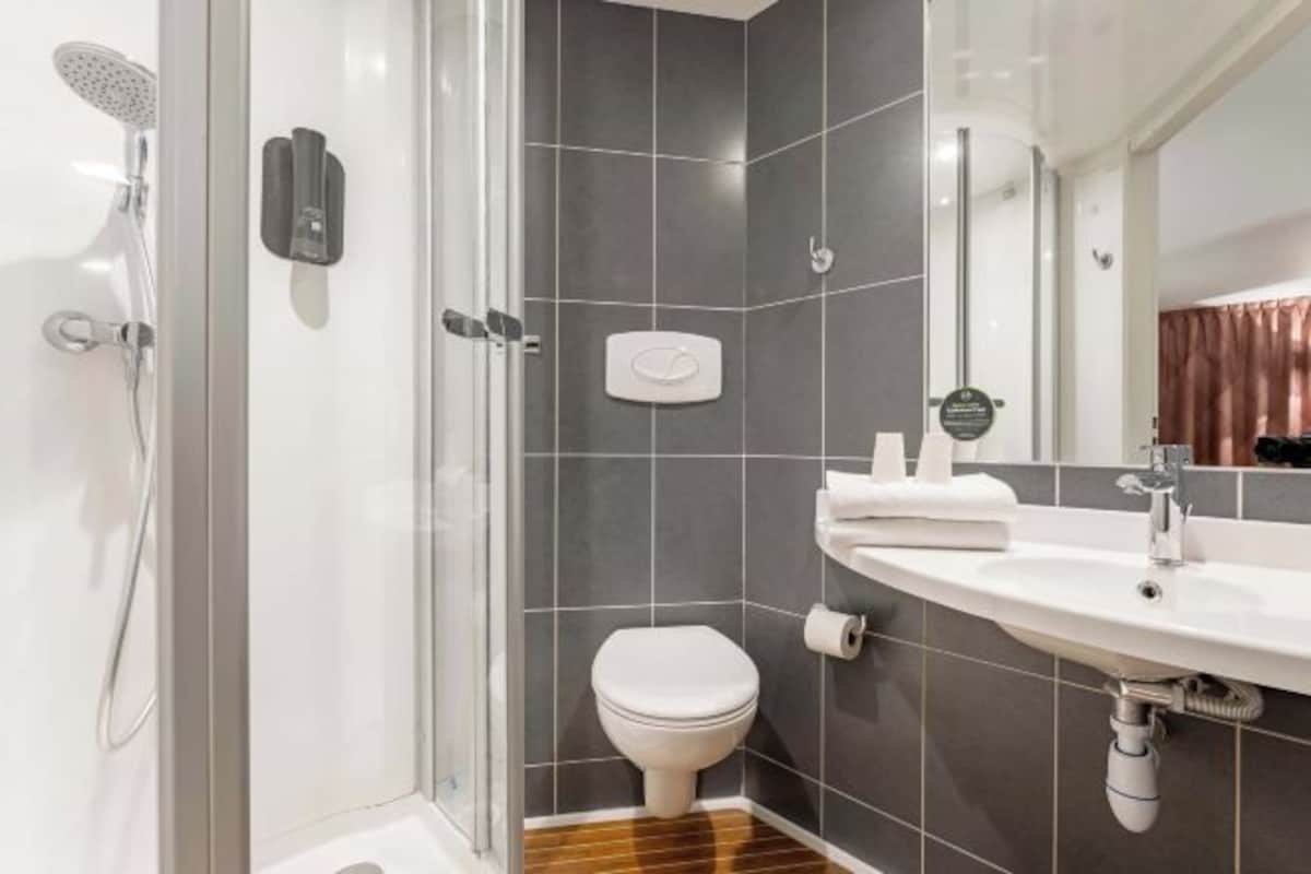 Un baño moderno con ducha, inodoro y lavamanos.