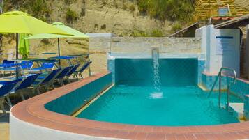 Piscine extérieure, parasols de plage, chaises longues