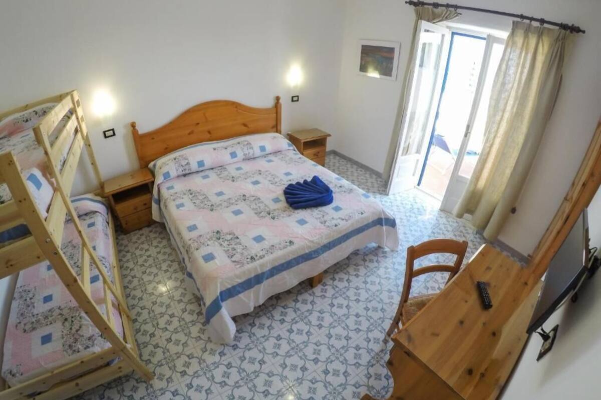 Une chambre à coucher avec un lit en bois, un bureau et une chaise.