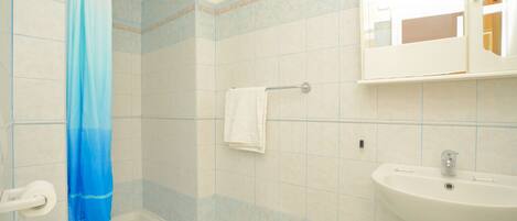 A bathroom with a shower, a sink, and a toilet.