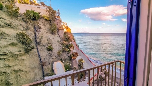 A balcony with a view of the sea and a rocky coastline. - Hotel Regina del Mare (Barano d'Ischia)