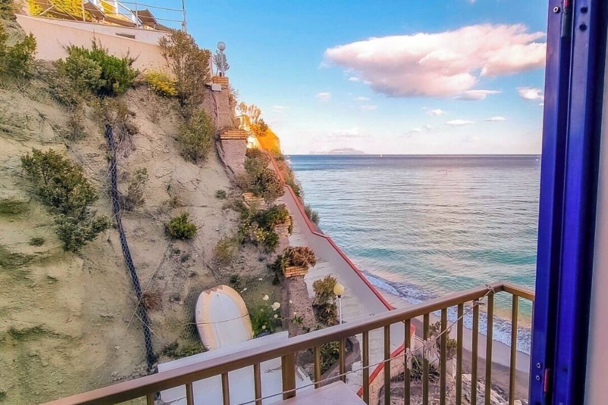 Un balcon avec vue sur la mer et une côte rocheuse.