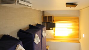 A hotel room with two beds, a flat-screen TV, a wooden cabinet, and a window with curtains. - Hostal Conchita Legazpi (Madrid)
