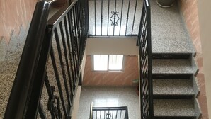 A multi-level interior with a staircase, potted plants, and a window providing natural light. - Hostal Conchita Legazpi (Madrid)