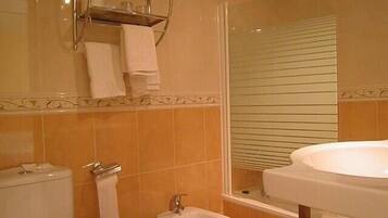 A bathroom with a toilet, bidet, and sink.