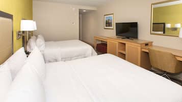 Une chambre d’hôtel avec deux lits, un bureau avec une télévision et un miroir.
