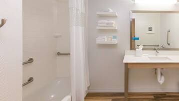 A modern bathroom with a shower, a sink, and a mirror.