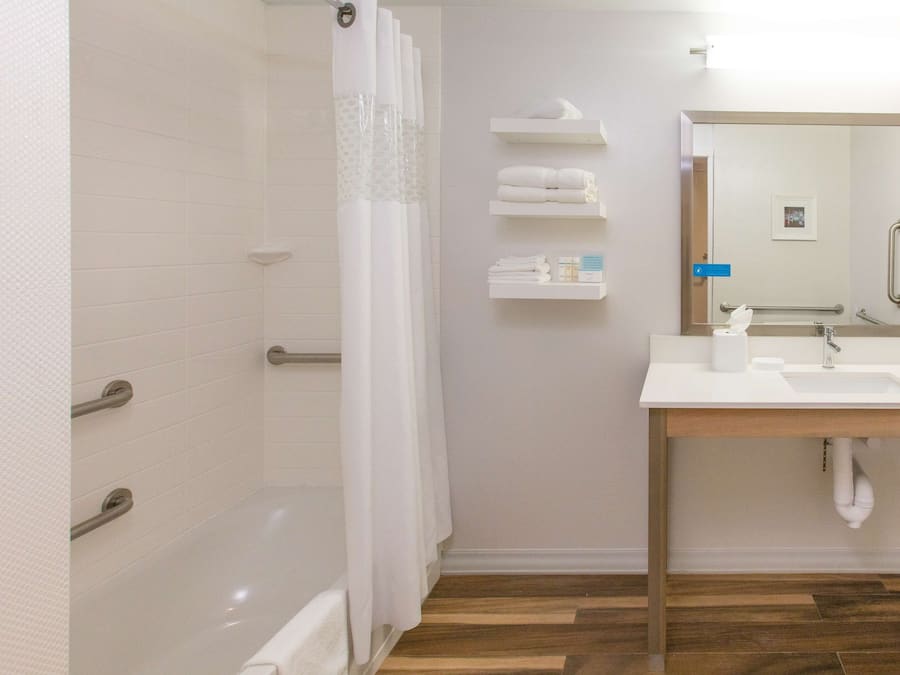 A modern bathroom with a shower, a sink, and a mirror.