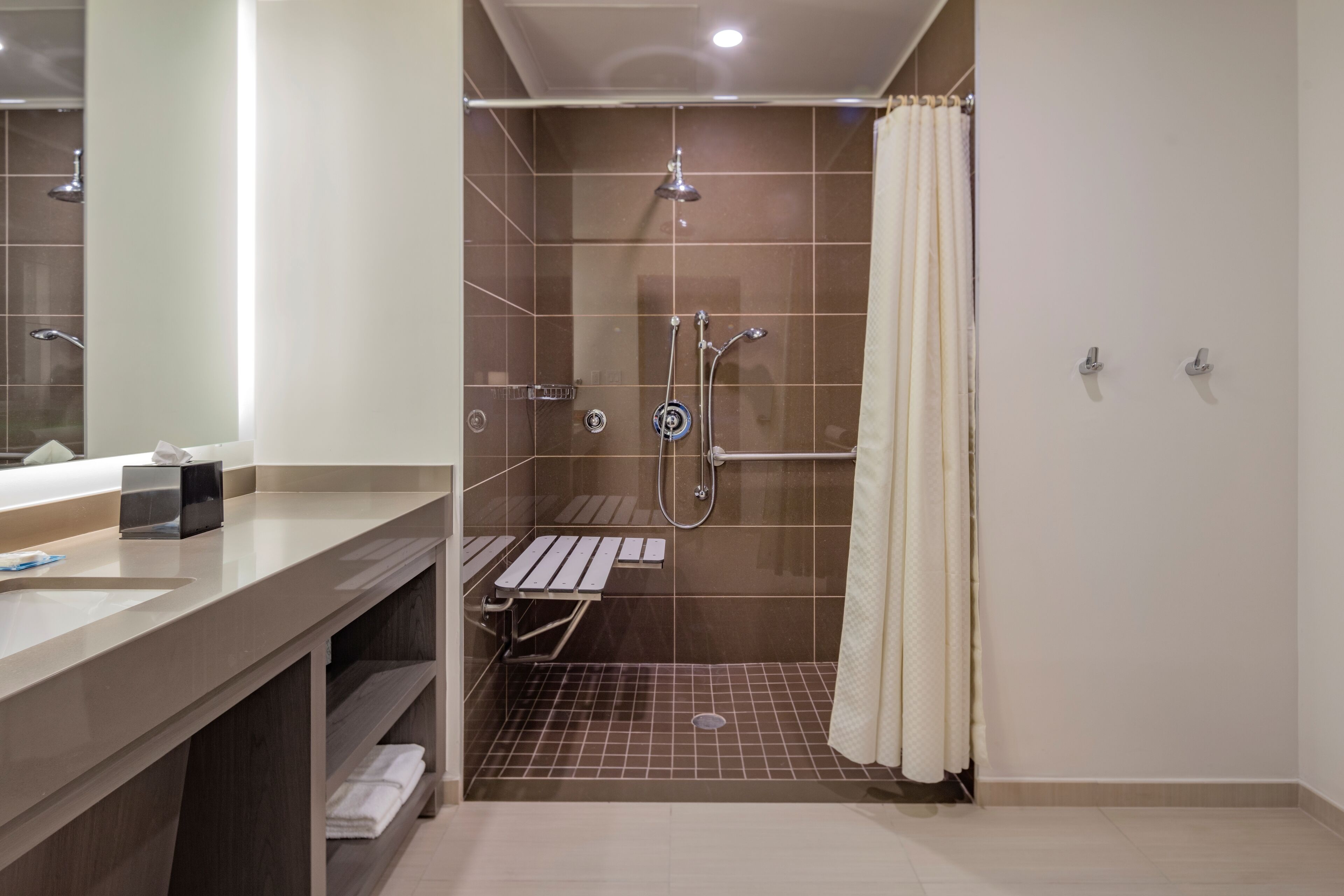 Une salle de bain moderne équipée d’une douche, d’un lavabo et d’un meuble-lavabo.