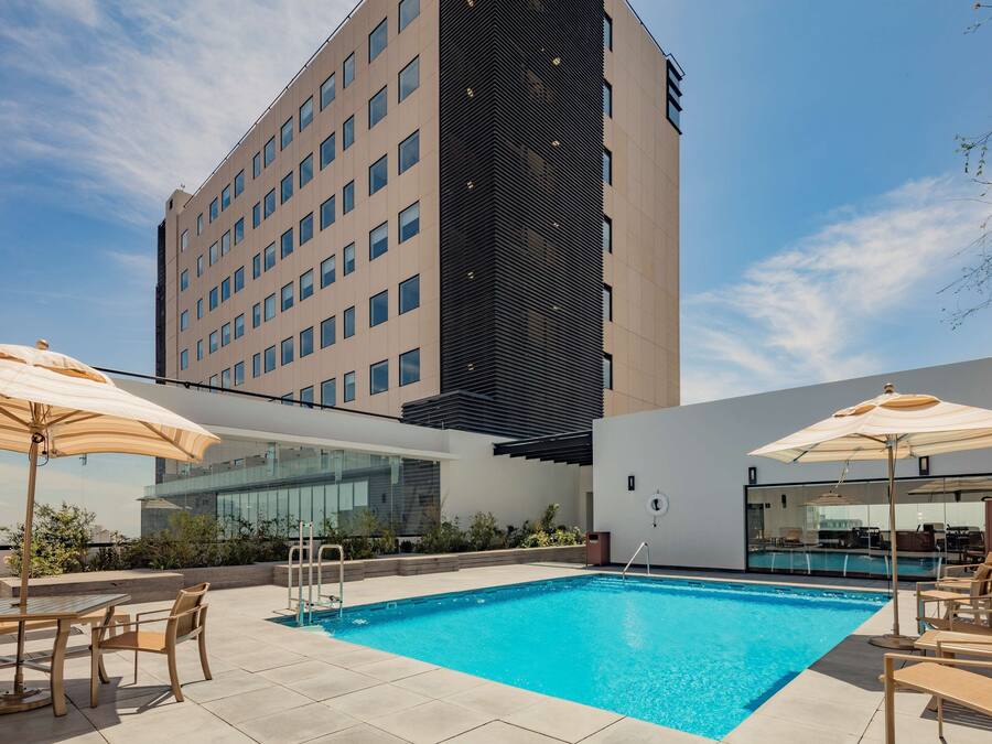 Una piscina al aire libre, sillones reclinables de piscina