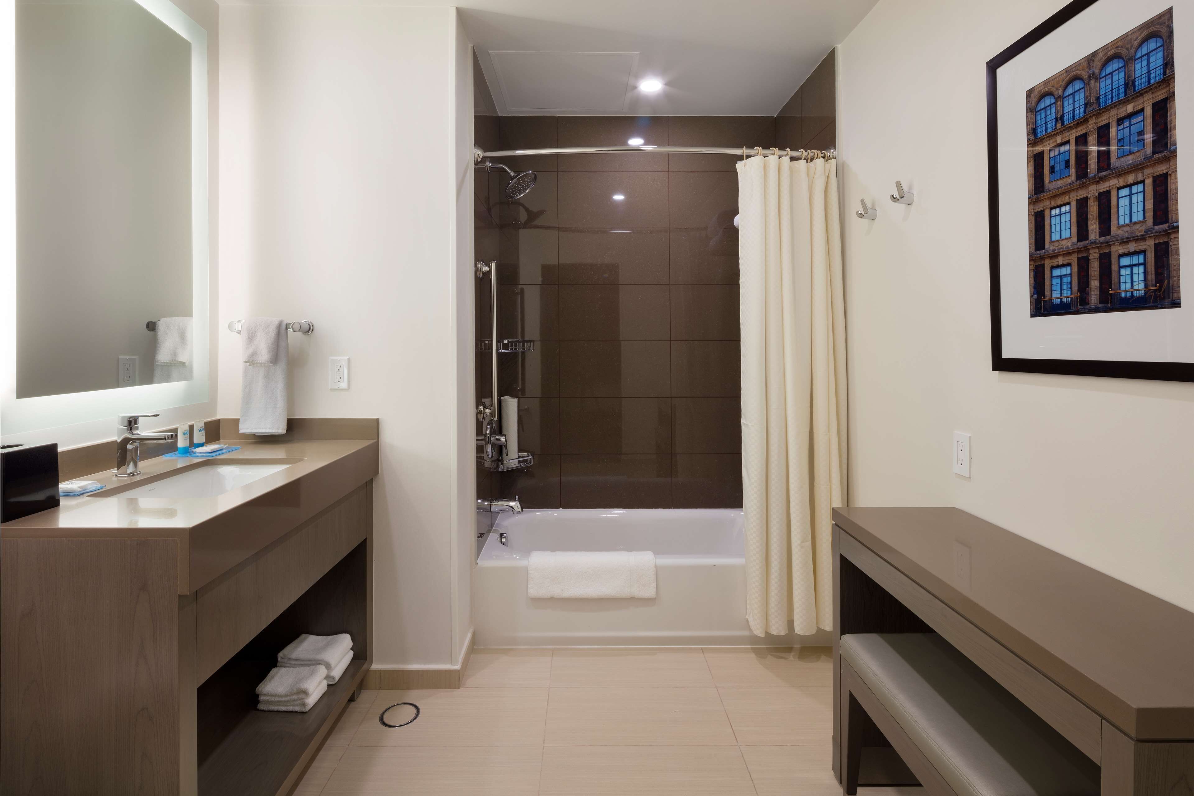 A modern bathroom with a bathtub, shower, and two sinks.