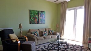 A living room with a sofa, armchairs, a coffee table, and a patterned rug.