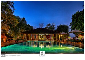 A poolside area with lounge chairs and umbrellas, a building with a tiled roof, and a clear sky. - Lake Lodge Boutique Hotel Kandalama (Kandalama)