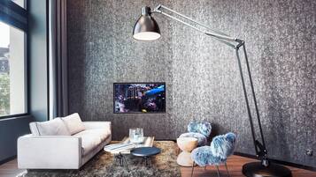 A modern living room with a sofa, a coffee table, a floor lamp, and a television on a textured wall.