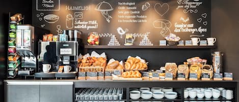 Mostrador de panadería con diversos productos horneados y equipo para café.