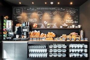 A bakery counter with various baked goods and coffee equipment.