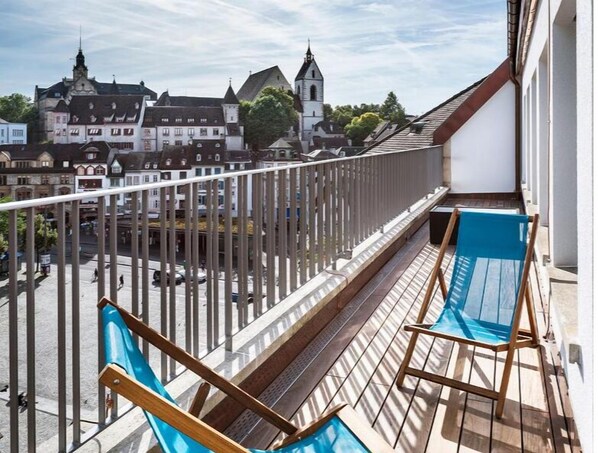 A balcony with a view of historic buildings and a church.