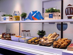 Un bufé de desayuno con diversos alimentos, como pan, bollería y salsas.