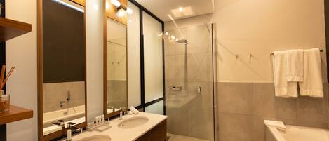 Un baño moderno con dos lavamanos, una cabina de ducha de vidrio y una bañera.