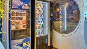 A vending machine with various snack options and a window display.