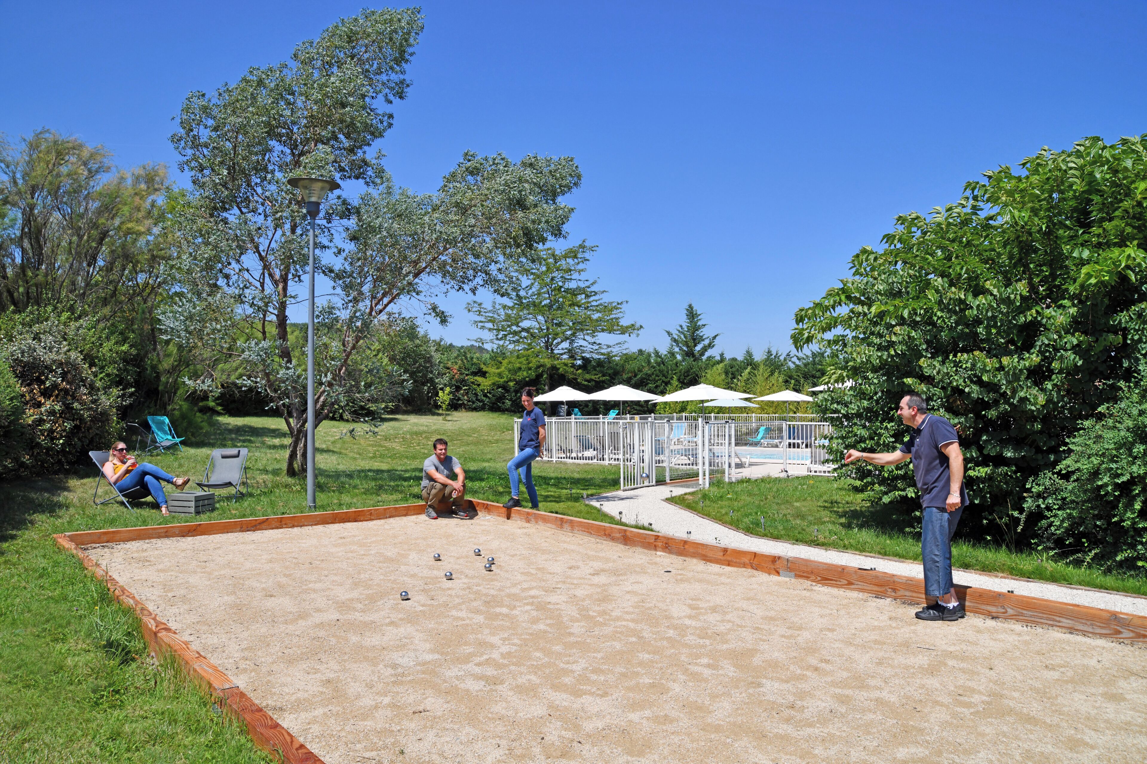 Un espacio al aire libre con mesa de billar, asientos y zona junto a la piscina.