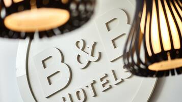 A B&B hotel sign with a circular design and a modern lamp.