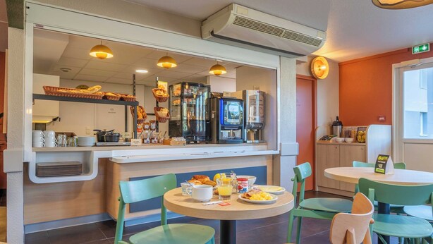 A breakfast area with a counter, seating, and a coffee machine. - B&B HOTEL Aix-en-Provence Meyreuil Sainte-Victoire (Meyreuil)