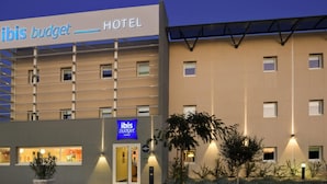 A modern hotel building with a sign reading "ibis budget HOTEL". - ibis budget Istres Trigance (Istres)