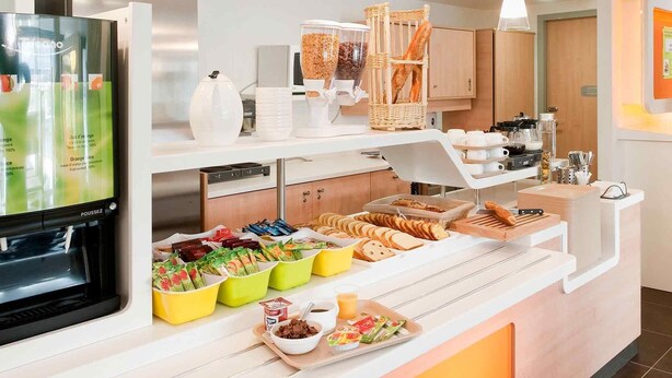 A breakfast buffet with various food items, a refrigerator, and a coffee station. - ibis budget Istres Trigance (Istres)