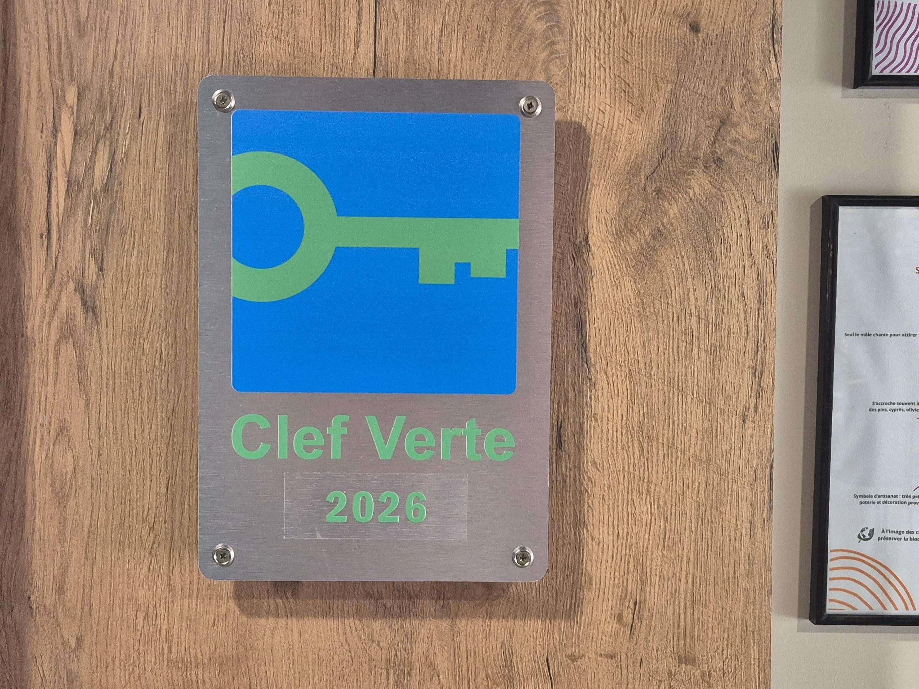 A plaque with a key symbol and the text 'Clef Verte 2026' mounted on a wooden surface.