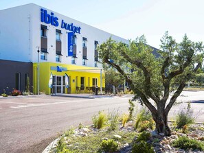 A modern building with the signage 'ibis budget' indicating a budget hotel. - ibis budget Saint Martin de Crau Porte de Camargue (Saint-Martin-de-Crau)