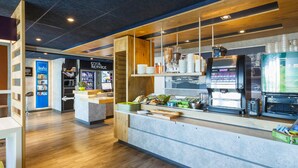 Een modern café met een houten toonbank, koffiemachines en een bedieningsgedeelte.